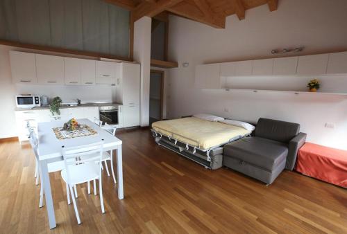 a room with a bed and a table and a kitchen at Residence Rose in Valdisotto