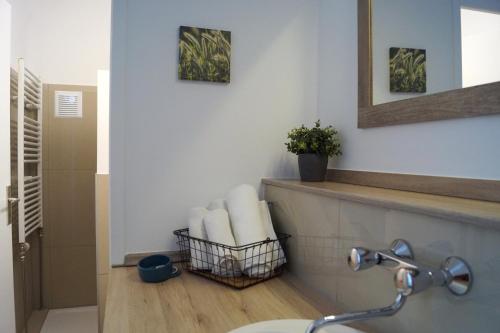 a bathroom with a sink and a basket of towels at Kraft Hotel Alzey Worms A61 in Gundersheim