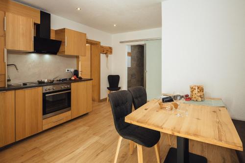 a kitchen with a wooden table and chairs in a room at Haus Piz Lad in Nauders