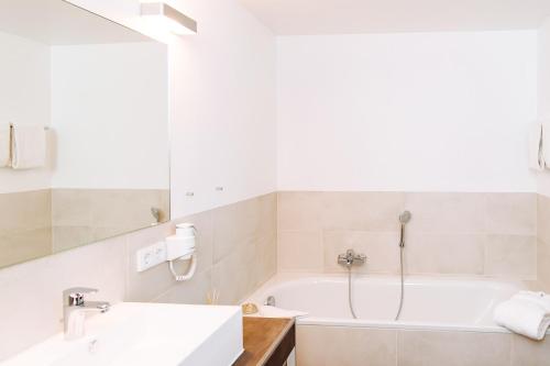 a bathroom with a tub and a sink at Landhotel Potsdam in Potsdam