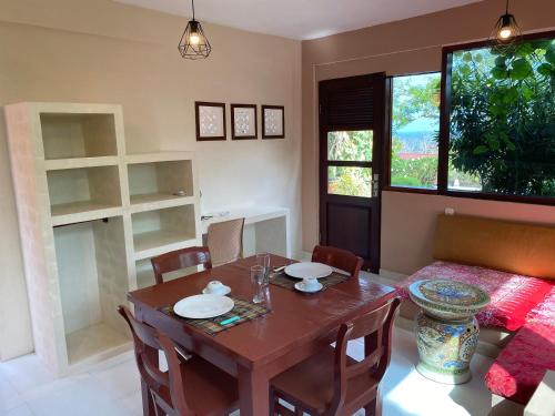 una sala da pranzo con tavolo e sedie in legno di Villa Anjing 2 a Nusa Dua