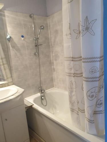 une salle de bain avec douche et baignoire blanche dans l'établissement Studio plage du Grazel, à Gruissan
