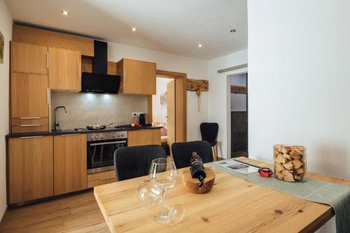 a kitchen with a wooden table with wine glasses on it at Haus Piz Lad in Nauders