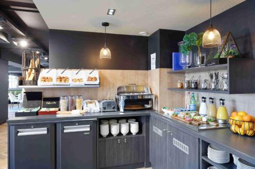 a kitchen with a counter with food on it at Kyriad Crepy En Valois in Crépy-en-Valois