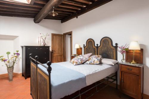 a bedroom with a large bed with a wooden headboard at Casa Dovi in Rosennano
