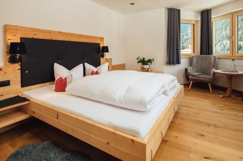 a bedroom with a large bed with a wooden headboard at Haus Piz Lad in Nauders