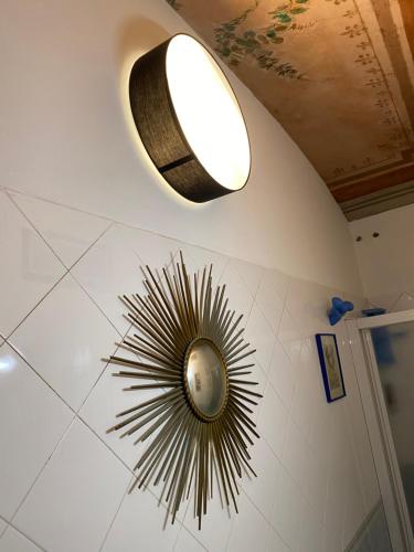 eine Uhr an der Wand mit einem Licht an der Decke in der Unterkunft KIKA’S HOUSE in Turin