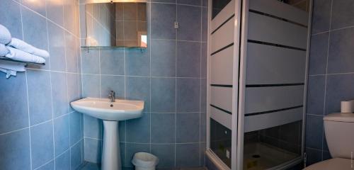 a bathroom with a sink and a shower at Hotel de la Gare in Châteauroux
