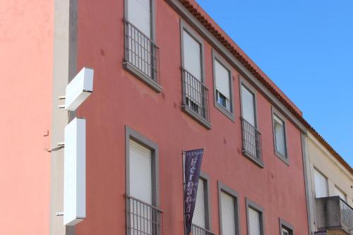 a red building with windows and a sign on it at Dom Fernando I in Loulé