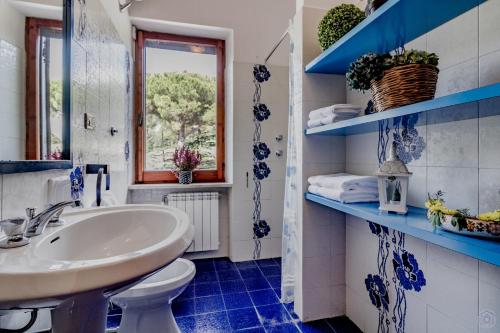 a blue and white bathroom with a sink and a toilet at Beautiful 2-storey villa in Todi (room for 18) in Todi