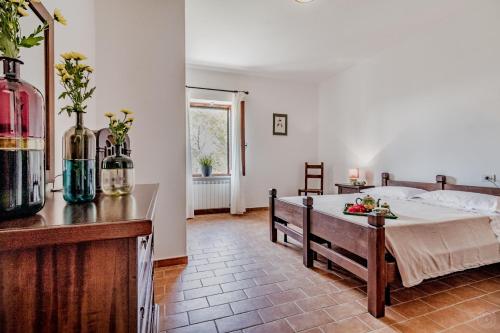 a bedroom with a bed and a table with flowers on it at Gorgeous 2-storey villa with a large private pool in Todi