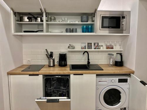 a kitchen with a sink and a washing machine at Duo 2 Debniki Apartment in Kraków