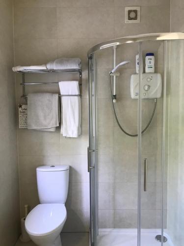 a bathroom with a shower and a toilet and towels at The Bridges Bed and Breakfast in Donegal
