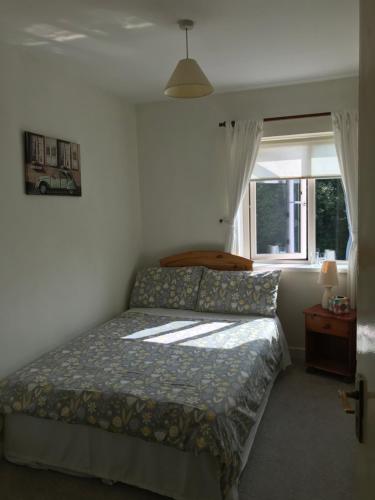 a bedroom with a bed and a window at The Bridges Bed and Breakfast in Donegal