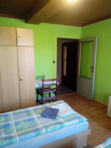 a bedroom with green walls and a bed and a table at Studánecký Medvěd in Liberec