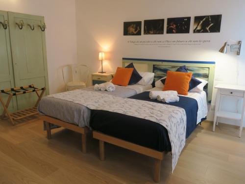 een slaapkamer met 2 bedden met oranje en blauw bij Foresteria Conti, sulle tracce di Shakespeare in Padua