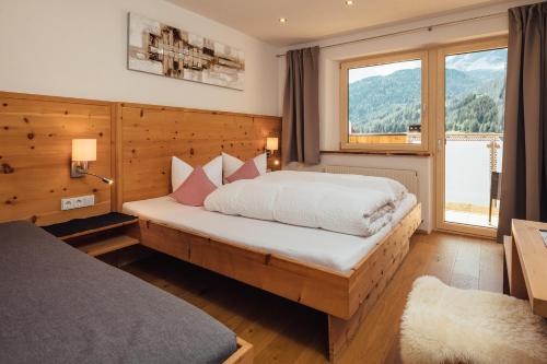 1 dormitorio con cama y ventana grande en Haus Piz Lad, en Nauders