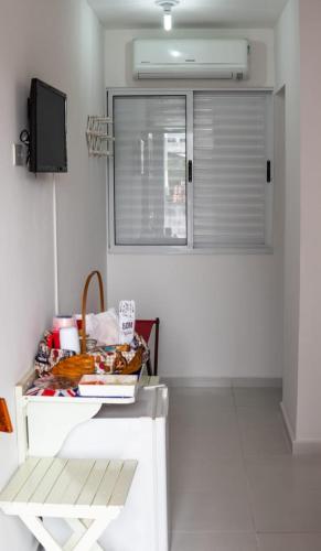a room with a white table and a window at Urbano Suítes in Ubatuba