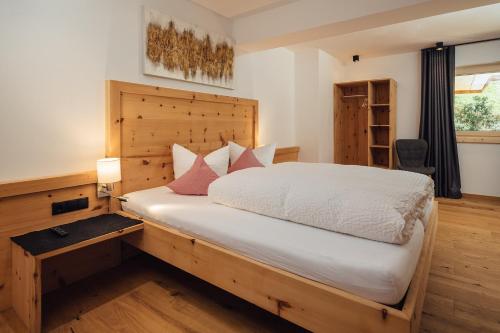 a bedroom with a large white bed with red pillows at Haus Piz Lad in Nauders