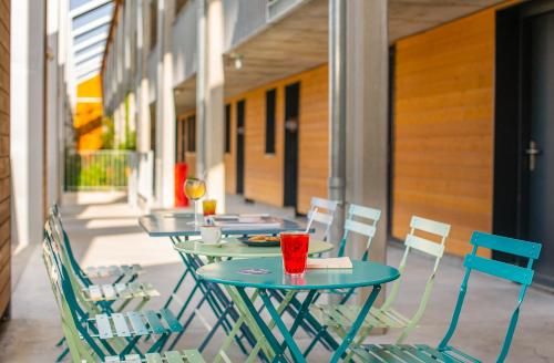 a row of tables and chairs on a patio at Eklo Bordeaux Centre Bastide in Bordeaux
