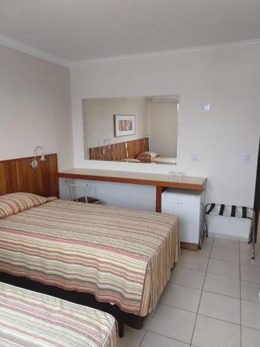 a hotel room with two beds and a sink at Hotel Riviera Lins in Lins