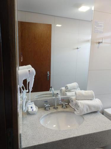a bathroom counter with a sink and a mirror at Hotel Riviera Lins in Lins