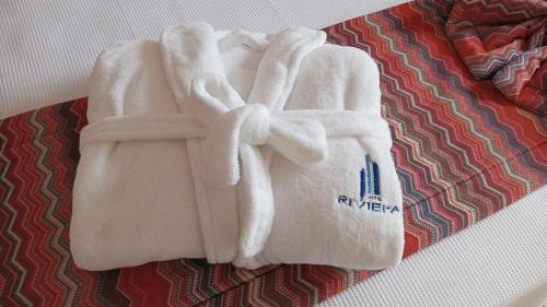 ein Paar weiße Handtücher auf dem Bett in der Unterkunft Hotel Riviera Lins in Lins