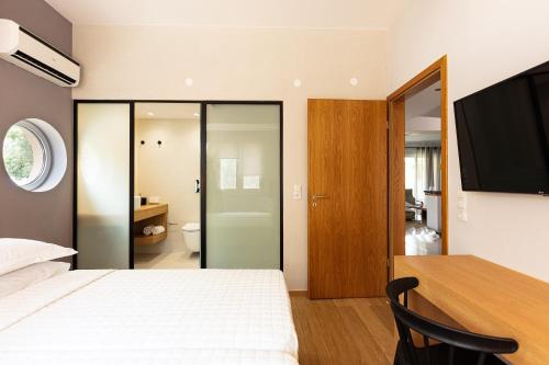 a bedroom with a bed and a desk with a television at TheTree Villa, with Heated Pool & Spa Whirlpool in Gállos