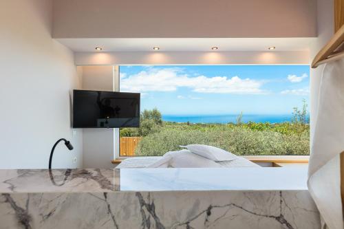 a bedroom with a large window with a view of the ocean at TheTree Villa, with Heated Pool & Spa Whirlpool in Gállos