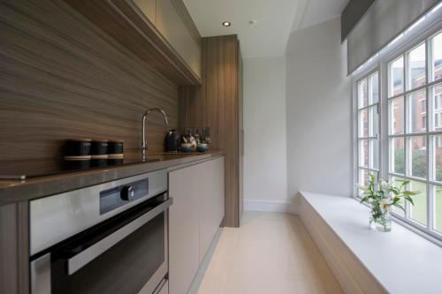 een keuken met een wastafel en een raam bij ChocoLets - The Foss Suite in York