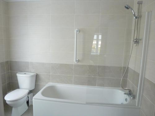 a bathroom with a white tub and a toilet at Orrell Park Hotel in Liverpool