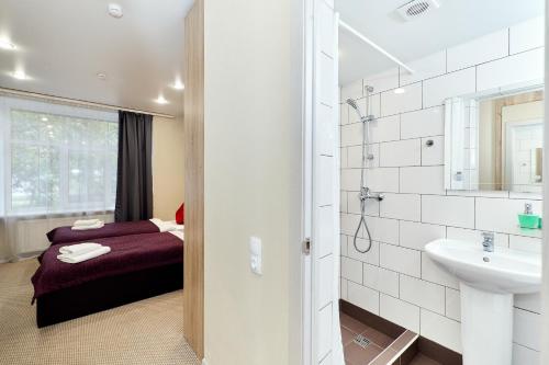 a bathroom with a bed and a sink and a mirror at Piter by ACADEMIA in Saint Petersburg