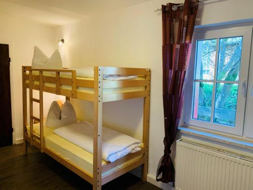 2 Etagenbetten in einem Zimmer mit Fenster in der Unterkunft Baude Steinheid am Rennsteig mit 12 Betten in Steinheid