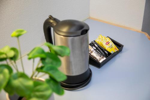 a coffee pot sitting on a counter next to a plant at Hotel Uusikuu in Mikkeli