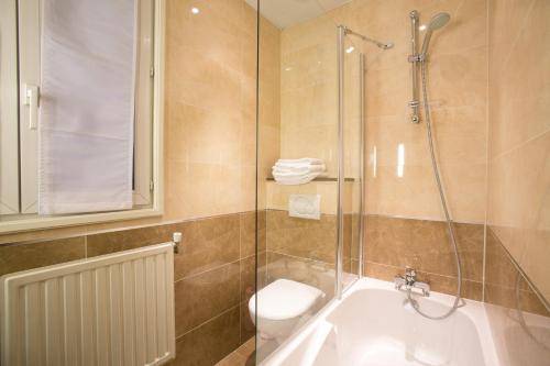 a bathroom with a shower and a toilet and a sink at Hotel Bellevue Saint-Lazare in Paris