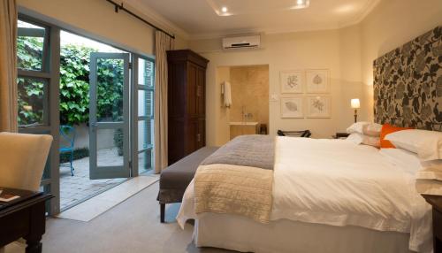 a bedroom with a large bed and a sliding glass door at Parkwood Boutique Hotel in Johannesburg