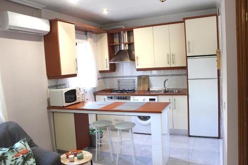 a small kitchen with white cabinets and a counter at Acogedor apartamento en EL VALLE DEL JERTE 1 in Piornal