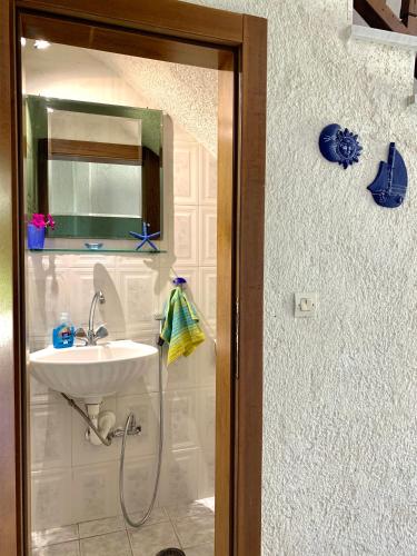 a bathroom with a sink and a mirror at Stella's Maisonette in Siviri