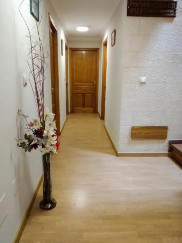 a hallway with a vase with flowers in it at Hotel Puente Vidosa in Amieva