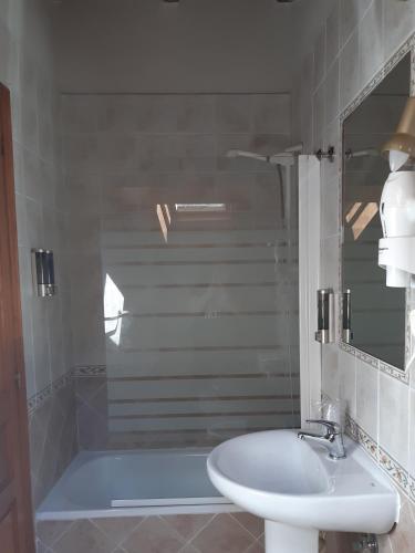 a bathroom with a sink and a bath tub at Hotel Puente Vidosa in Amieva