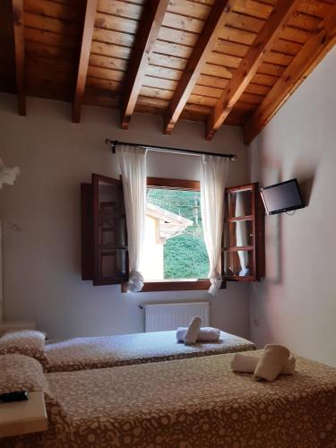 a bedroom with two beds and a window at Hotel Puente Vidosa in Amieva