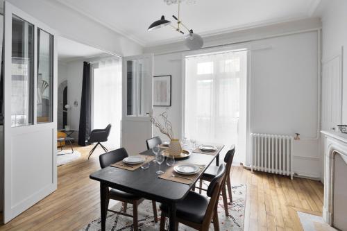 une salle à manger avec une table et des chaises noires dans l'établissement Le Contour Saint-Aubin - Inspiration Art Déco en cœur de Ville, à Rennes