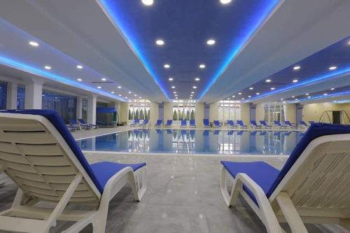 a large swimming pool with chairs in a building at VILIN in Niš