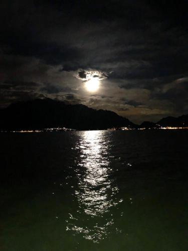 a full moon over a body of water at night at Casa Ivana in Menaggio