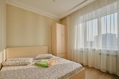トムスクにあるАпартаменты Советская 60のベッドルーム1室(ベッド1台、大きな窓付)