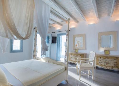 1 dormitorio blanco con 1 cama con dosel y 2 sillas en Luxury Paros Villa Superior Villa Private Pool Stunning Interior 7 BDR Tserdakia en Kampos Paros