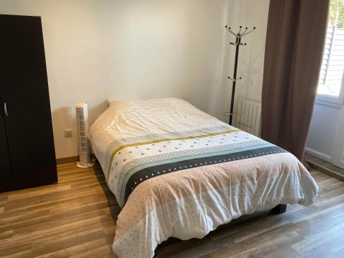 ein kleines Bett in einem Schlafzimmer mit Holzboden in der Unterkunft Legend- Parking privé Gratuit- Terrasse privée- Wifi - Convert - Alimentec in Bourg-en-Bresse