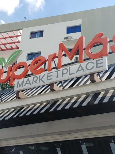 a sign on the front of a shopping center at Torre Real IV L3 Santiago DR con cocinero para desayuno in Santiago de los Caballeros