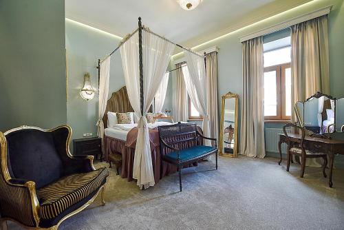 a bedroom with a canopy bed and a chair at Inner Blossom in Kaunas