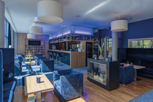 a lobby with blue furniture and a fireplace at Seminaris CampusHotel Berlin in Berlin